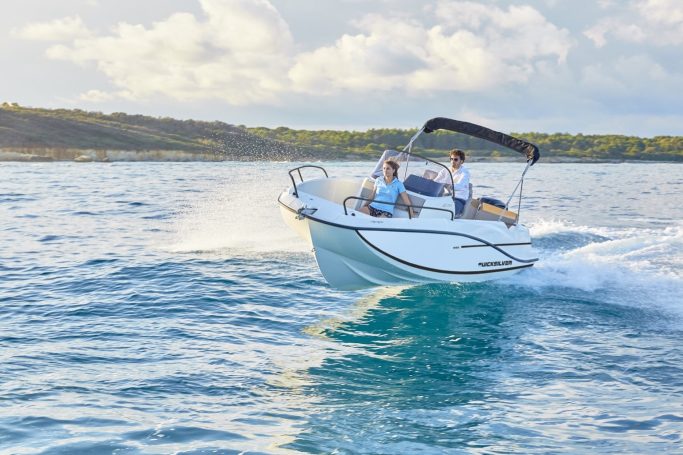 Pareja navegando lancha quicksilver 605 open.